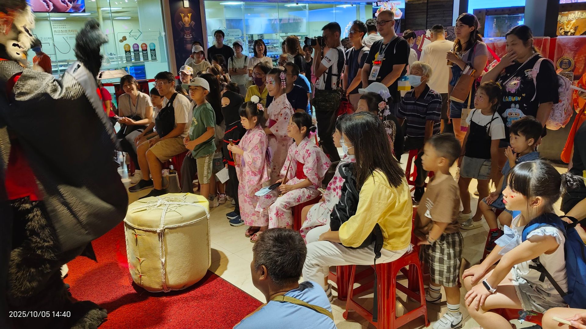 獸裝角色在展場前對著大批觀眾表演，台下坐滿穿浴衣的孩童與家長