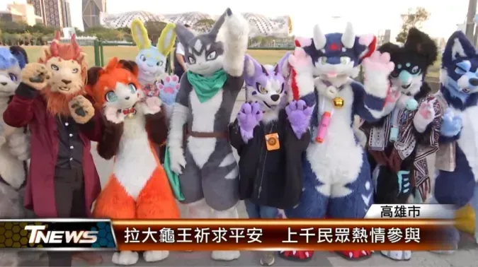 A TNEWS broadcast still of fursuiters — including lion, red panda and husky characters — posing outdoors together, captioned "Pulling the Giant Turtle King for blessings, thousands join enthusiastically."