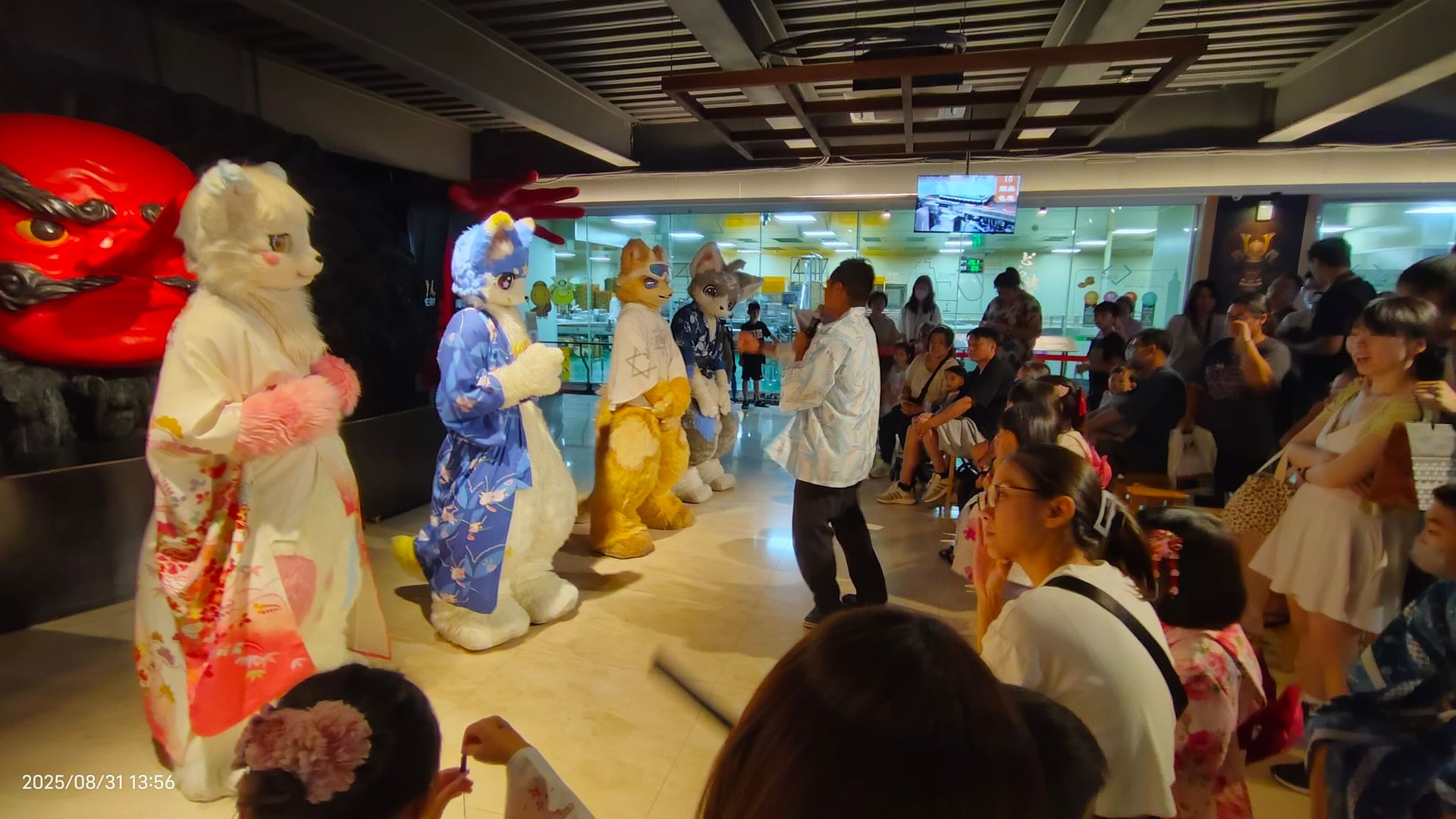 多隻獸裝角色列隊在觀眾面前表演，一旁小男孩隨之起舞互動
