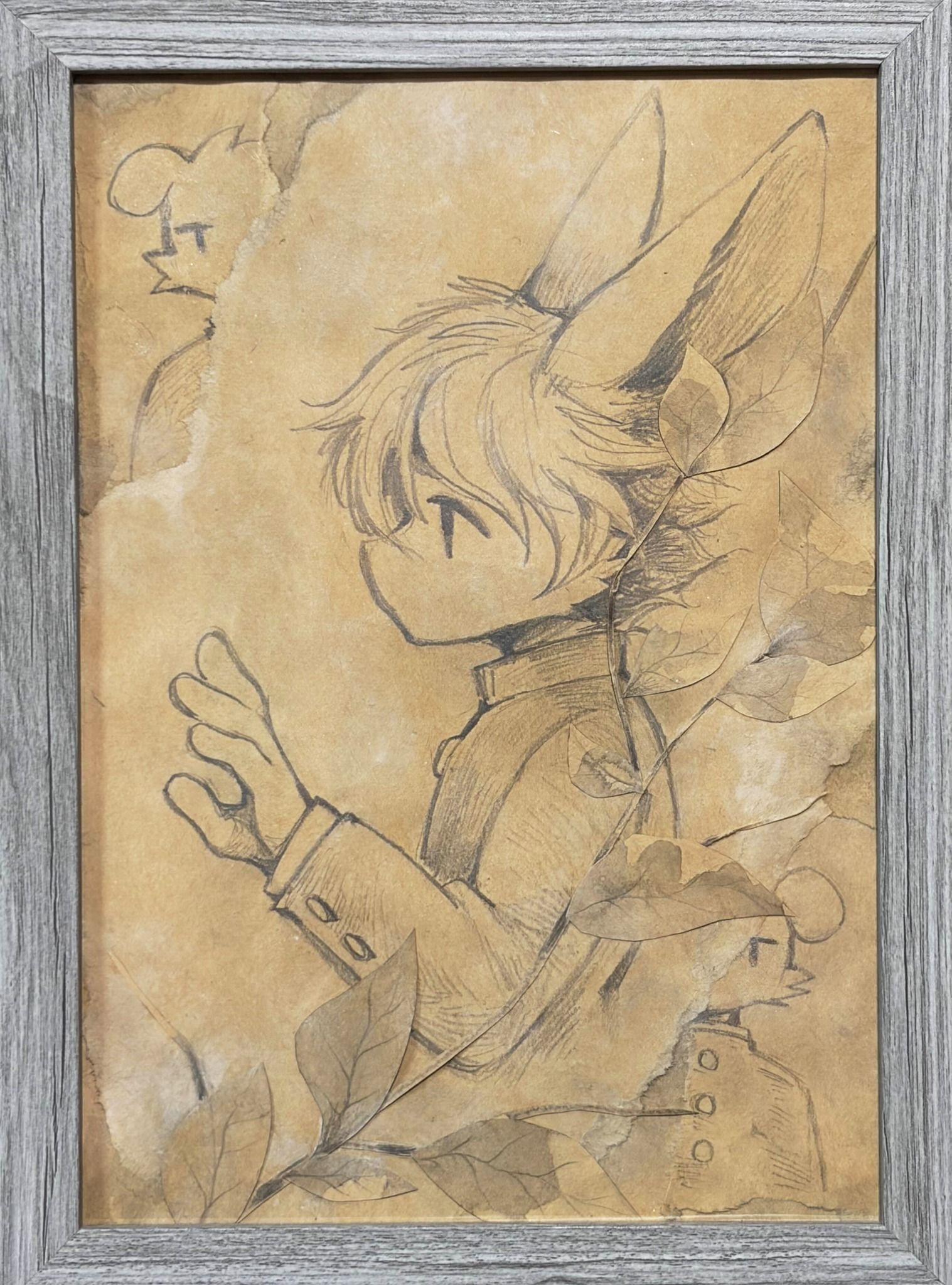 參展原畫:兔耳角色側身伸手的鉛筆素描,搭配乾燥葉片拼貼於做舊紙面上,裝裱於木框中