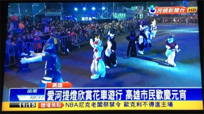 A nighttime FTV News broadcast showing the caption "Love River lantern float parade, Kaohsiung citizens celebrate the Lantern Festival," with fursuiters marching in the parade.