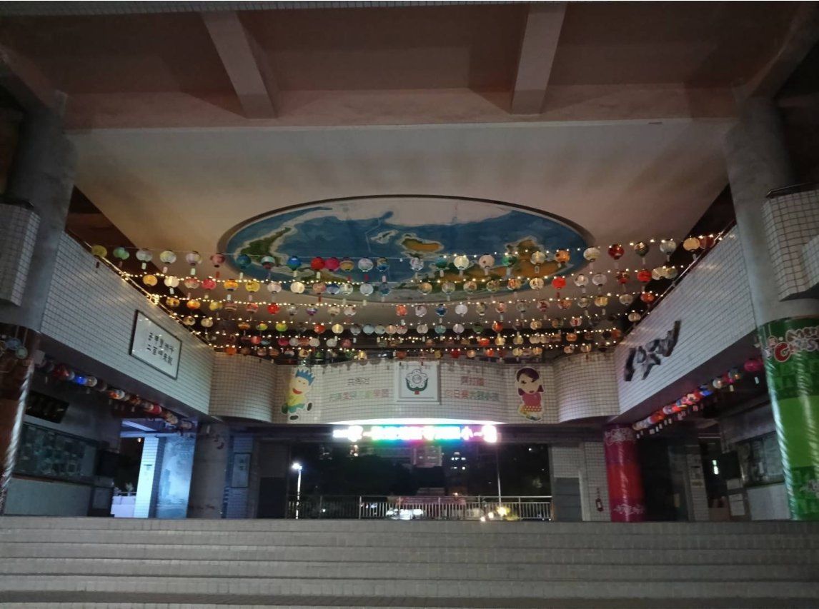 地下通道天花板懸掛滿滿的彩色紙燈籠，燈籠上方繪有台灣地圖，夜間拍攝