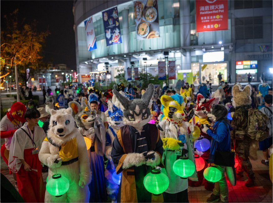 多名獸裝參加者手提發光紙燈籠在夜間街道遊行，後方大樓招牌林立，為官方活動攝影公開的代表照片之一。