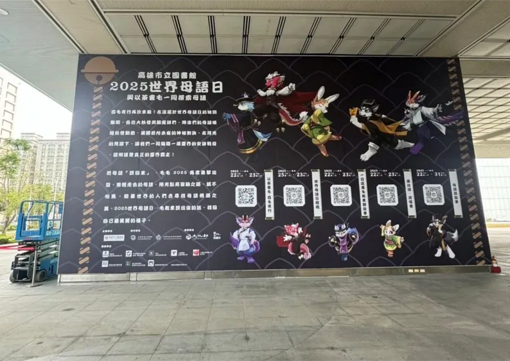 Large-scale mural for "2025 International Mother Language Day, exploring mother tongues with Furry Tea Party," installed on a building's covered walkway, with character illustrations and QR codes.
